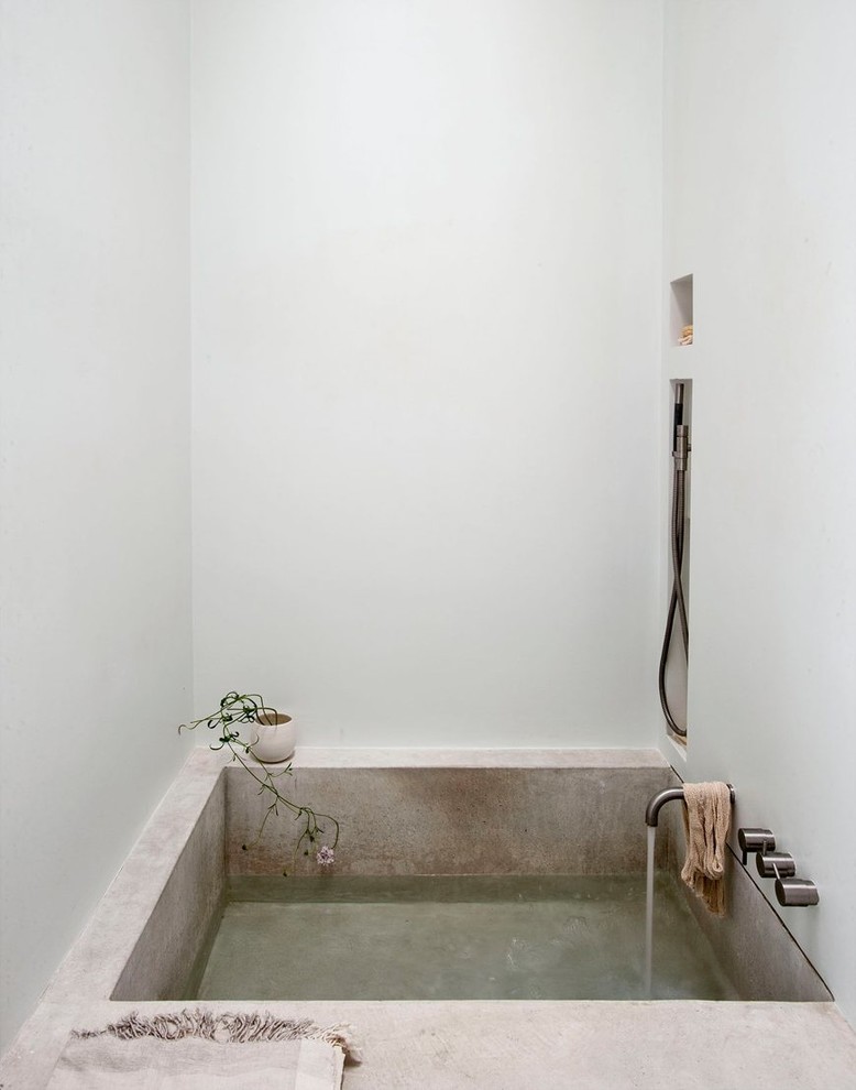 Skandinavisk inredning av ett litet badrum, med en dusch/badkar-kombination, vita väggar och ett badkar i en alkov