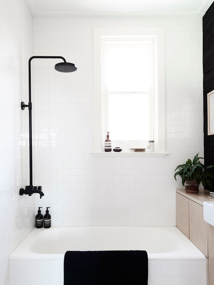 Foto på ett litet skandinaviskt en-suite badrum, med en dusch/badkar-kombination, vit kakel, vita väggar, ett fristående handfat och ett badkar i en alkov