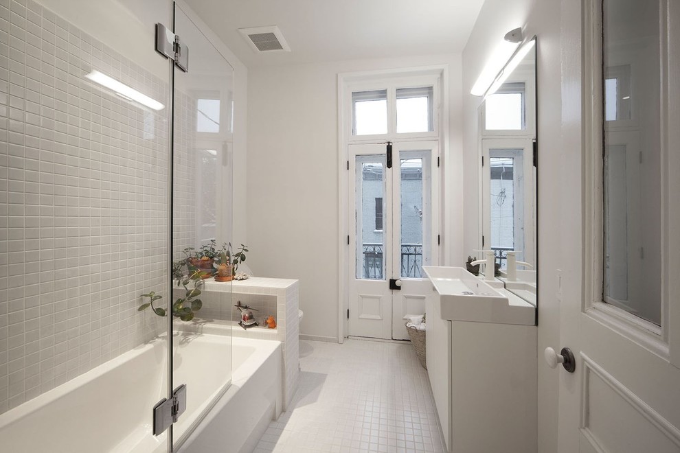 Skandinavisk inredning av ett mellanstort en-suite badrum, med ett integrerad handfat, ett hörnbadkar, en dusch/badkar-kombination, en toalettstol med hel cisternkåpa, mosaik, vita väggar och vit kakel