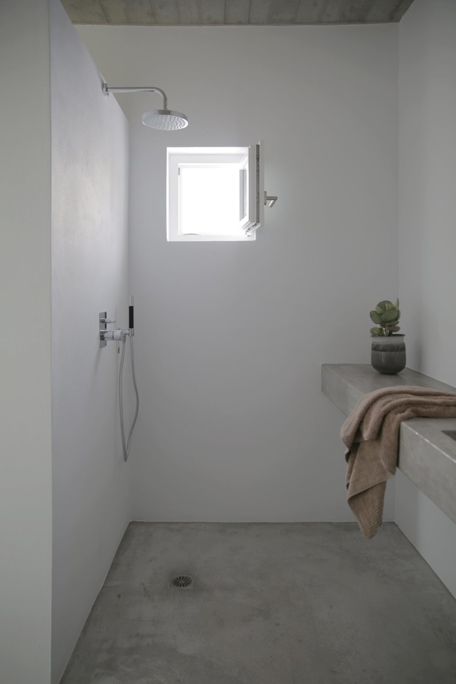 他の地域にある中くらいな地中海スタイルのおしゃれな浴室 (オープン型シャワー、白い壁、コンクリートの床、コンクリートの洗面台、オープンシャワー) の写真