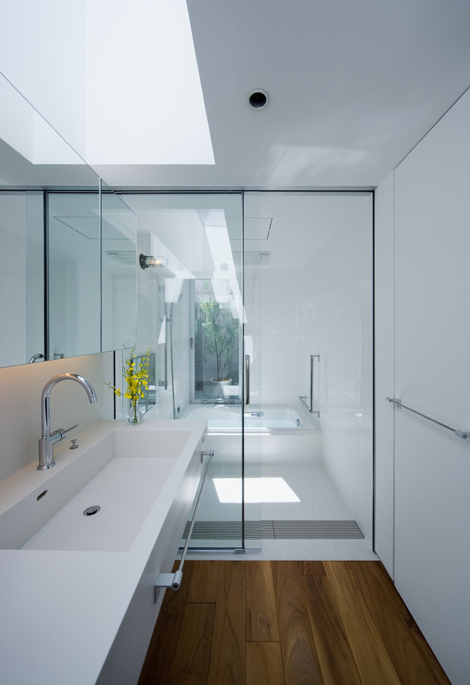 Ispirazione per una stanza da bagno padronale design con vasca da incasso, doccia a filo pavimento, piastrelle bianche, pareti bianche e lavabo integrato