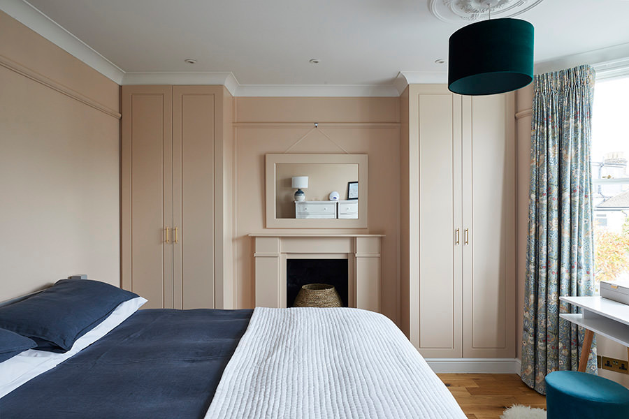Пример оригинального дизайна: хозяйская спальня среднего размера в стиле неоклассика (современная классика) с розовыми стенами, паркетным полом среднего тона, стандартным камином, фасадом камина из штукатурки, коричневым полом и стенами из вагонки