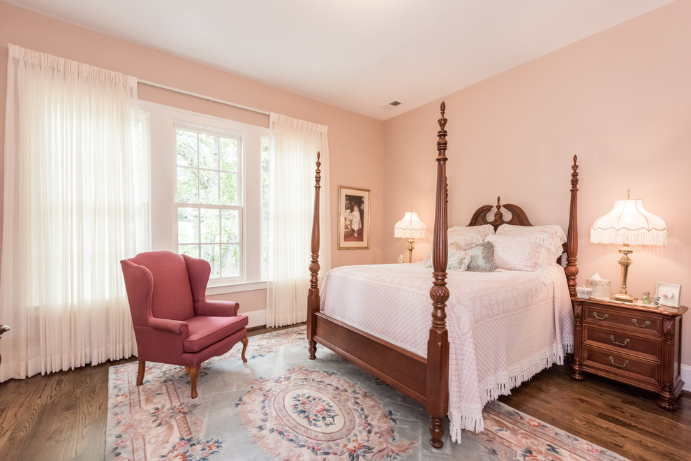 Diseño de habitación de invitados clásica con paredes rosas y suelo de madera oscura