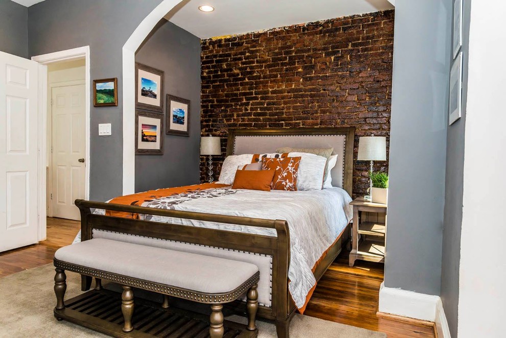 Foto de habitación de invitados tradicional de tamaño medio sin chimenea con paredes grises y suelo de madera clara