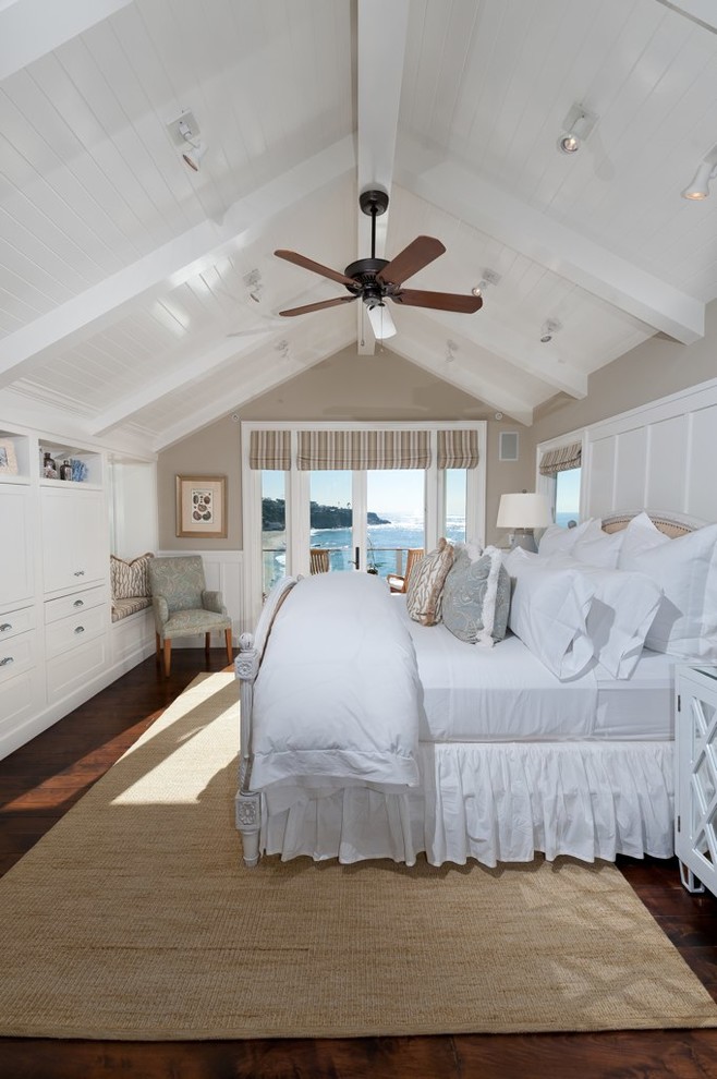 Large beach style master dark wood floor bedroom photo in Orange County with beige walls