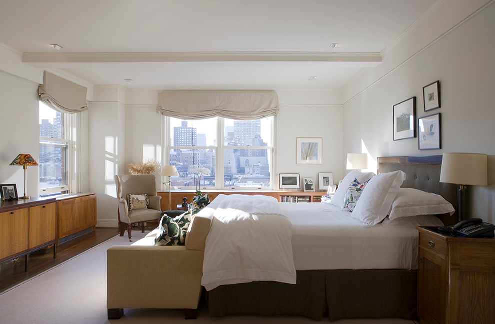 Klassisches Schlafzimmer ohne Kamin mit weißer Wandfarbe und dunklem Holzboden in New York