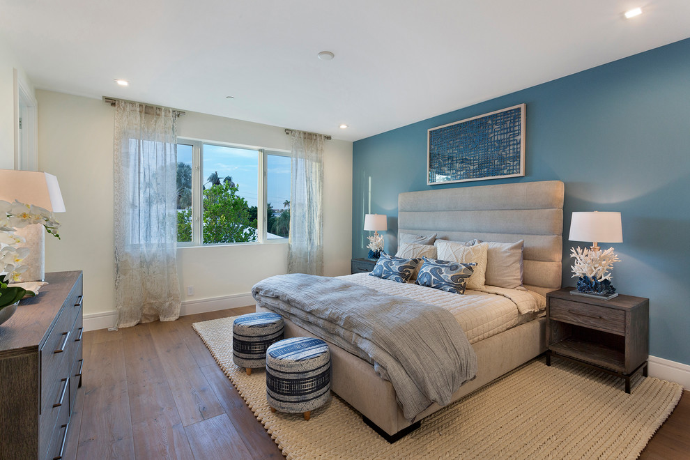 Esempio di una camera degli ospiti design di medie dimensioni con pareti blu, pavimento in legno massello medio, pavimento marrone e nessun camino