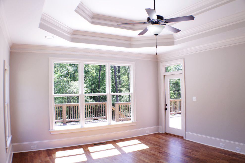 Großes Uriges Hauptschlafzimmer ohne Kamin mit grauer Wandfarbe und braunem Holzboden in Atlanta