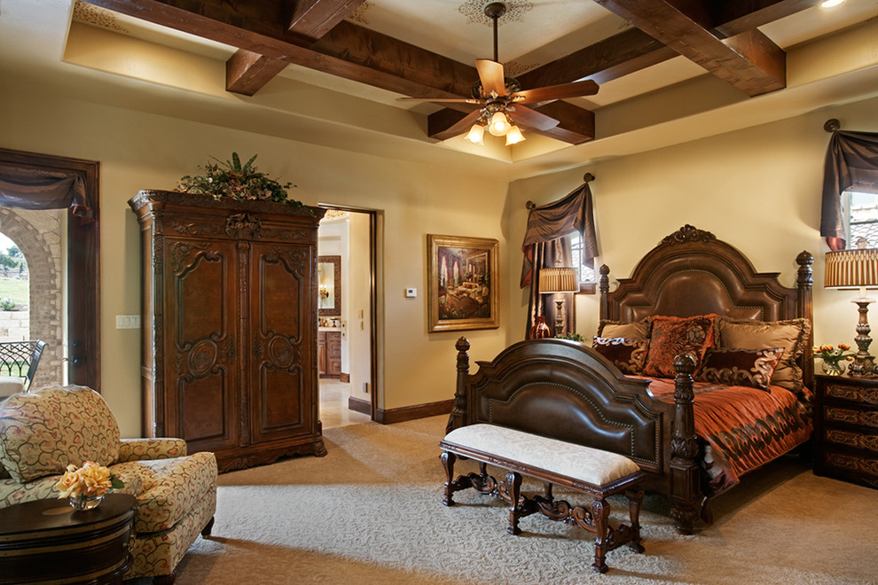 Example of a tuscan master carpeted bedroom design in Austin with beige walls and no fireplace