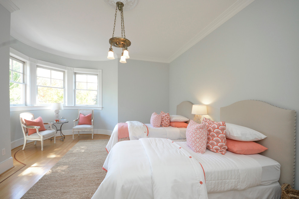 Modelo de habitación de invitados tradicional renovada con paredes azules y suelo de madera en tonos medios