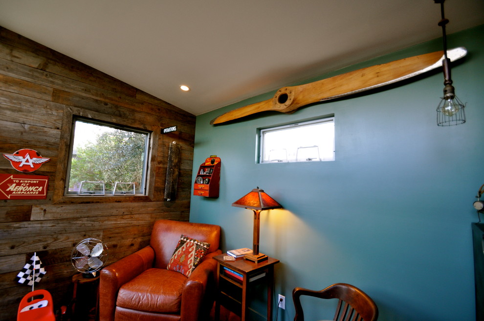 Cette image montre une petite chambre d'amis minimaliste avec un mur bleu et sol en béton ciré.