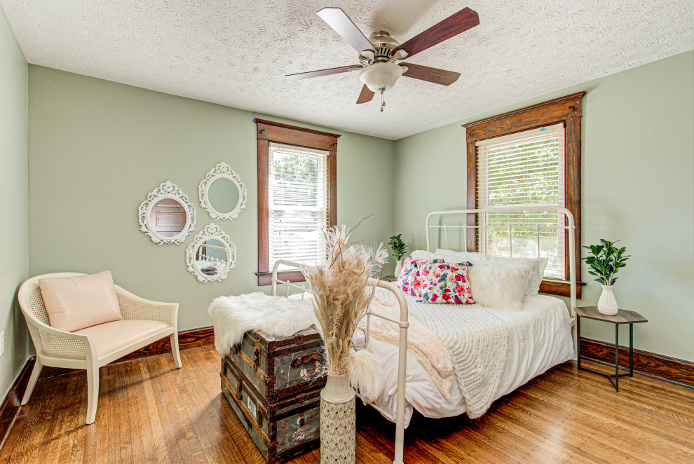 Mittelgroßes Landhaus Hauptschlafzimmer ohne Kamin mit grüner Wandfarbe, braunem Holzboden und braunem Boden in Indianapolis
