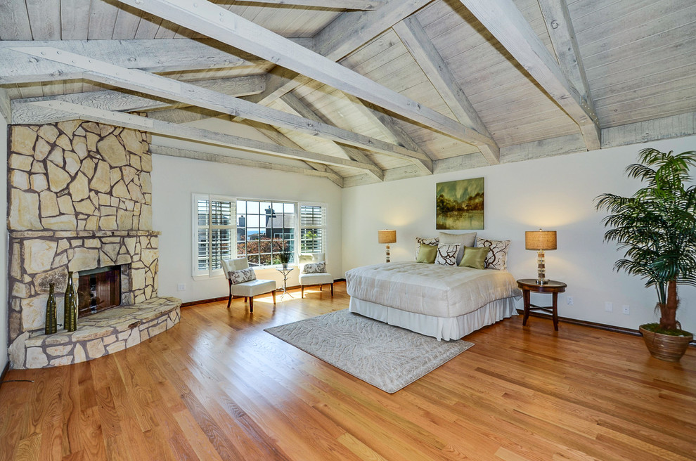 Klassisches Schlafzimmer mit weißer Wandfarbe, braunem Holzboden, Kamin und Kaminumrandung aus Stein in San Francisco