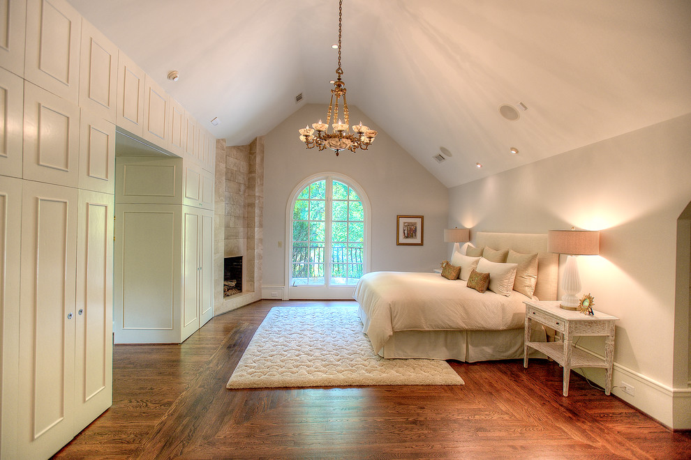 Bedroom - large mediterranean master medium tone wood floor bedroom idea in Atlanta with gray walls, a standard fireplace and a stone fireplace