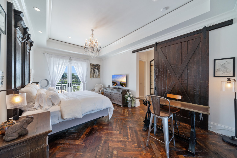 Diseño de dormitorio principal y televisión clásico renovado sin chimenea con paredes blancas, suelo de madera en tonos medios, suelo marrón y bandeja