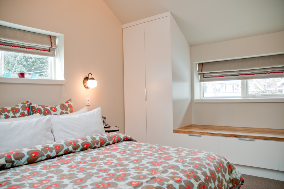 Ejemplo de dormitorio principal contemporáneo con paredes beige y moqueta