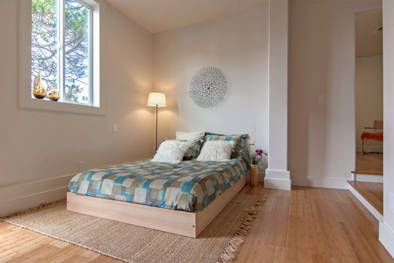 Ejemplo de habitación de invitados actual de tamaño medio con paredes grises y suelo de bambú