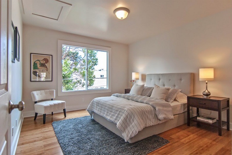 Imagen de dormitorio principal actual de tamaño medio con paredes grises y suelo de madera clara