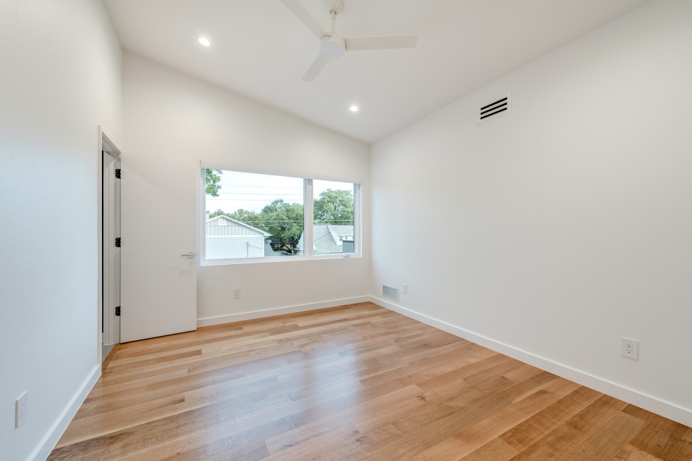 Idée de décoration pour une chambre d'amis minimaliste avec un mur blanc, un sol en bois brun et un sol marron.