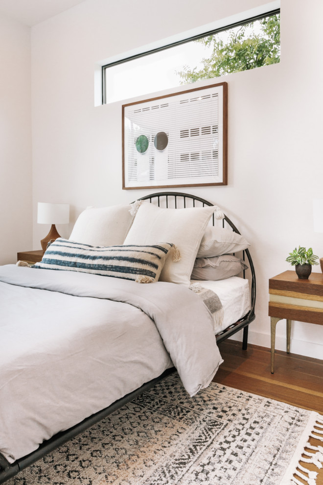Modernes Schlafzimmer mit weißer Wandfarbe, braunem Holzboden und braunem Boden in Austin