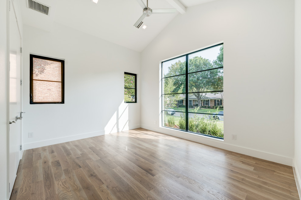 Inspiration for a large contemporary guest medium tone wood floor and brown floor bedroom remodel in Dallas with white walls