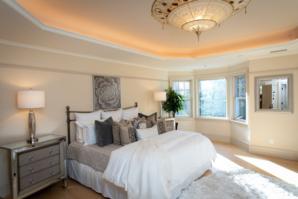 Inspiration for a large classic master bedroom in Boston with beige walls and light hardwood flooring.