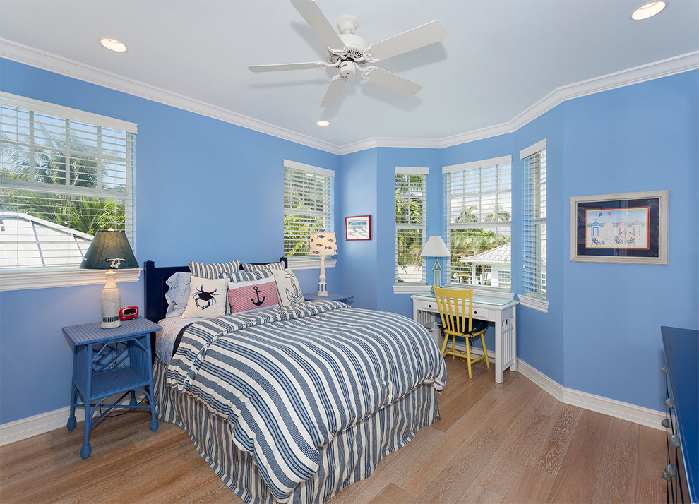 Diseño de habitación de invitados marinera de tamaño medio sin chimenea con paredes azules, suelo de madera clara y suelo beige