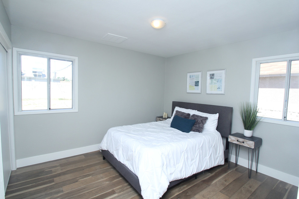 Example of a small 1960s guest laminate floor and brown floor bedroom design in Las Vegas with gray walls and no fireplace