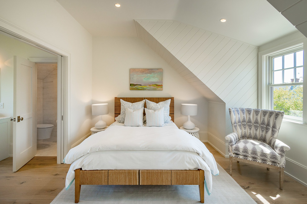 This is an example of a coastal master loft bedroom in Other with white walls, light hardwood flooring and beige floors.