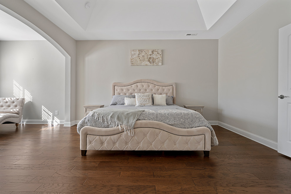 Foto de dormitorio tradicional con paredes beige, suelo de madera oscura y suelo marrón