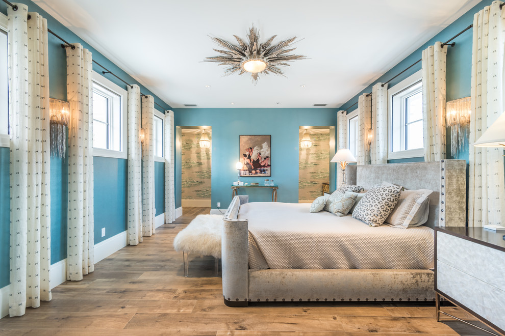 Ispirazione per una camera da letto tropicale con pareti blu e parquet chiaro