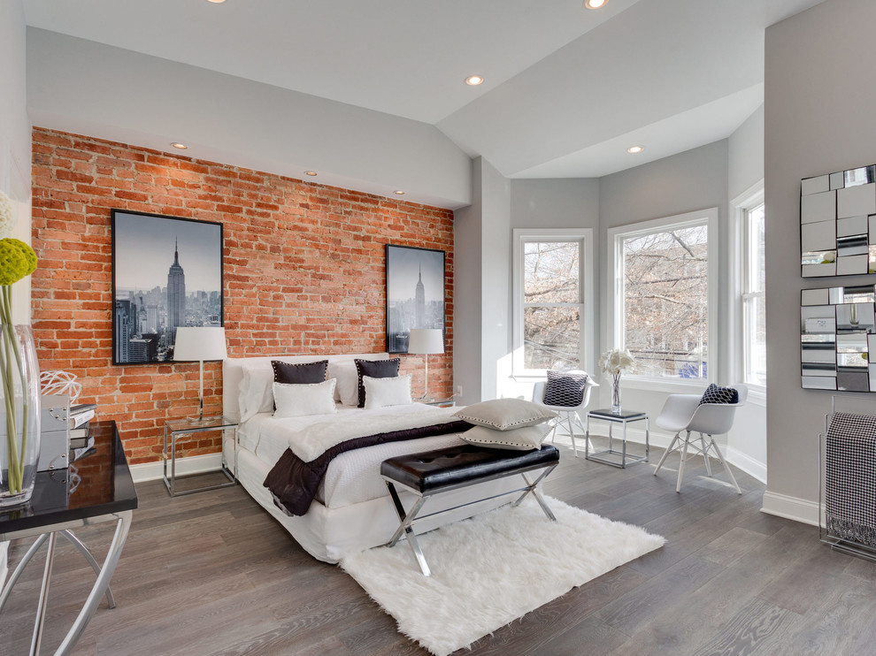 Example of a large trendy master medium tone wood floor and brown floor bedroom design in New York with gray walls and no fireplace