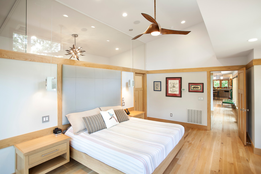 他の地域にある中くらいなコンテンポラリースタイルのおしゃれな主寝室 (白い壁、淡色無垢フローリング、暖炉なし、茶色い床、グレーとブラウン)