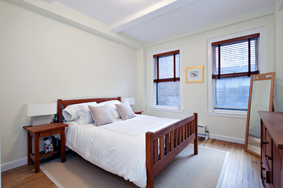 Inspiration for a small traditional guest bedroom in New York with white walls and light hardwood flooring.