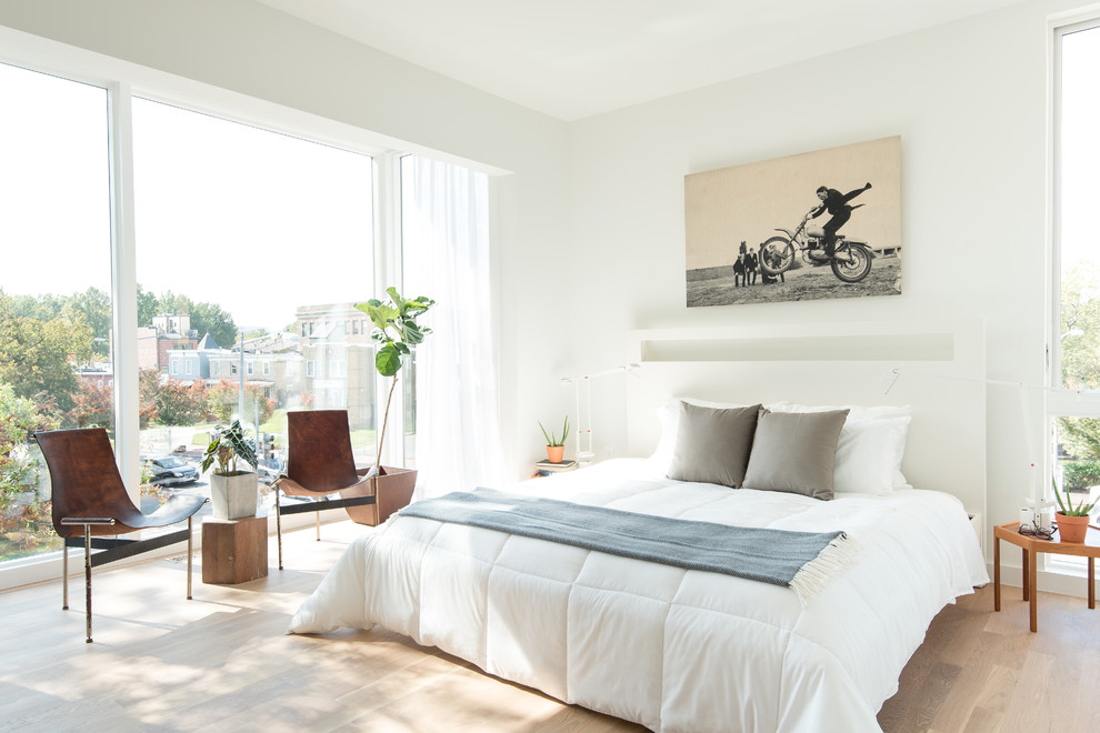 Immagine di una camera da letto scandinava con pareti bianche, parquet chiaro e pavimento beige