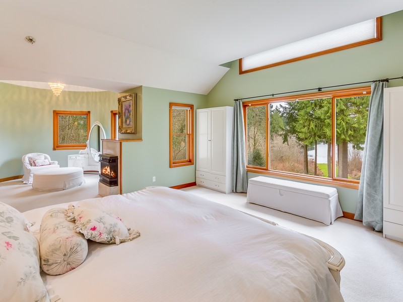 Imagen de dormitorio principal ecléctico extra grande con paredes verdes, moqueta, todas las chimeneas y marco de chimenea de piedra