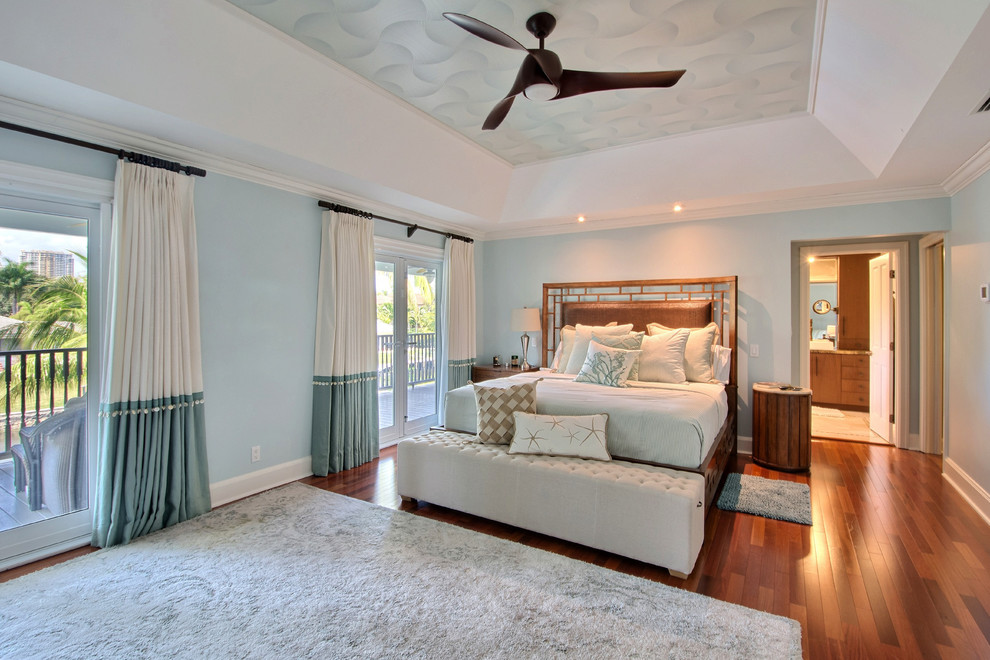 Idee per una camera da letto costiera con pareti blu, pavimento in legno massello medio e pavimento marrone