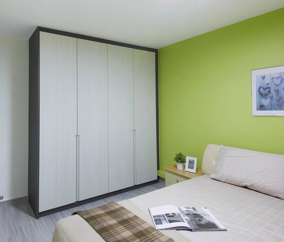 Modelo de dormitorio principal actual de tamaño medio con paredes verdes y suelo de contrachapado