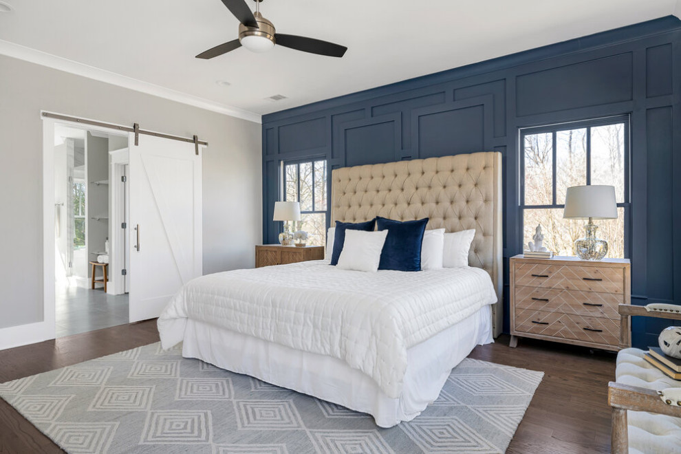 Modelo de dormitorio principal clásico renovado grande sin chimenea con paredes azules, suelo de madera oscura y suelo marrón