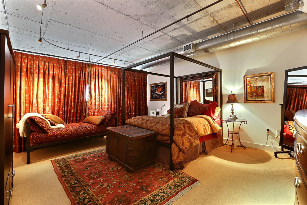 This is an example of an urban bedroom in Denver with beige walls and carpet.