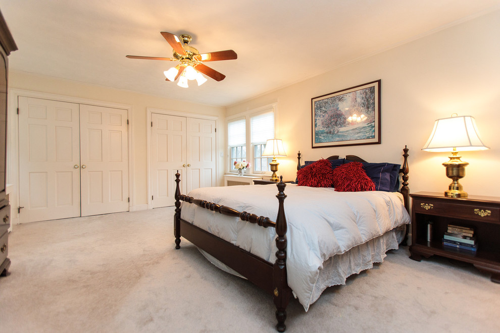 Large elegant master carpeted bedroom photo in Boston with beige walls
