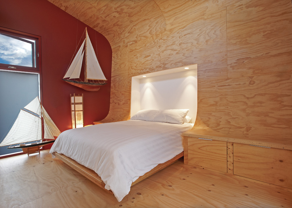 Imagen de dormitorio contemporáneo pequeño con paredes multicolor y suelo de contrachapado