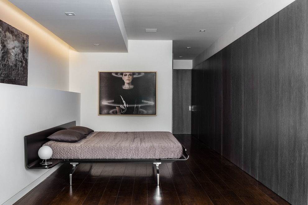 Ejemplo de dormitorio principal actual con paredes blancas y suelo de madera oscura