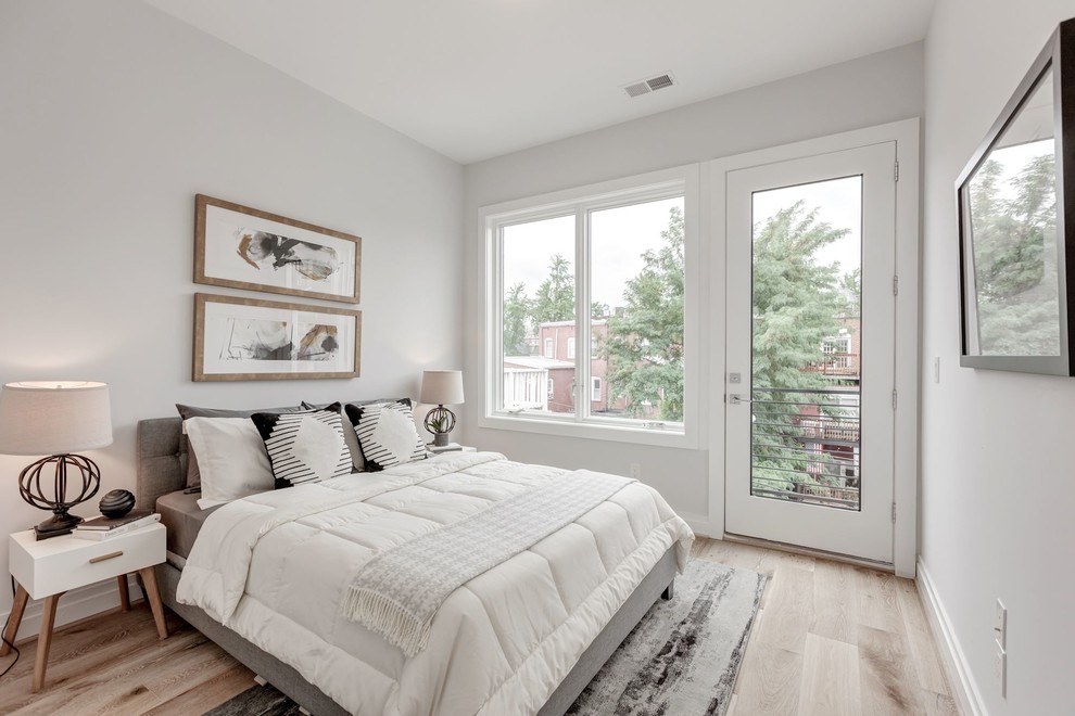 Immagine di una camera da letto minimal con pareti grigie, parquet chiaro e pavimento beige