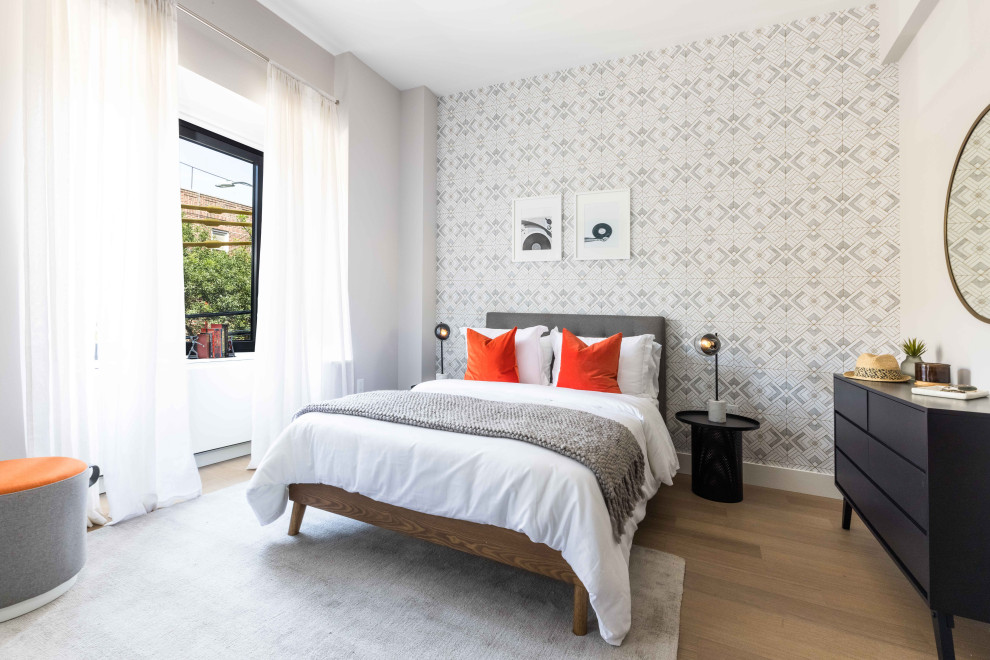 Cette photo montre une chambre tendance avec un mur gris, un sol en bois brun, un sol marron et du papier peint.