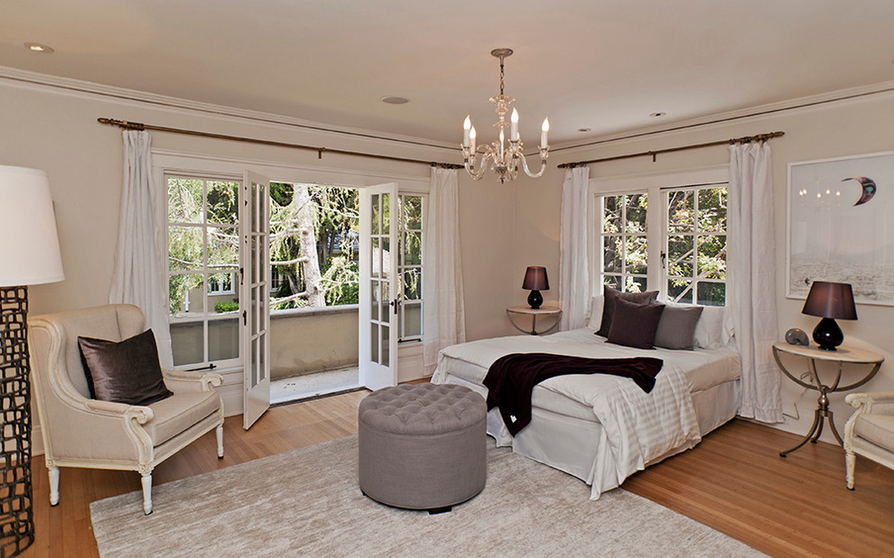 Example of a classic medium tone wood floor bedroom design in Los Angeles with beige walls