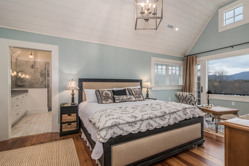 Foto de dormitorio principal tradicional renovado grande con paredes azules y suelo de madera en tonos medios