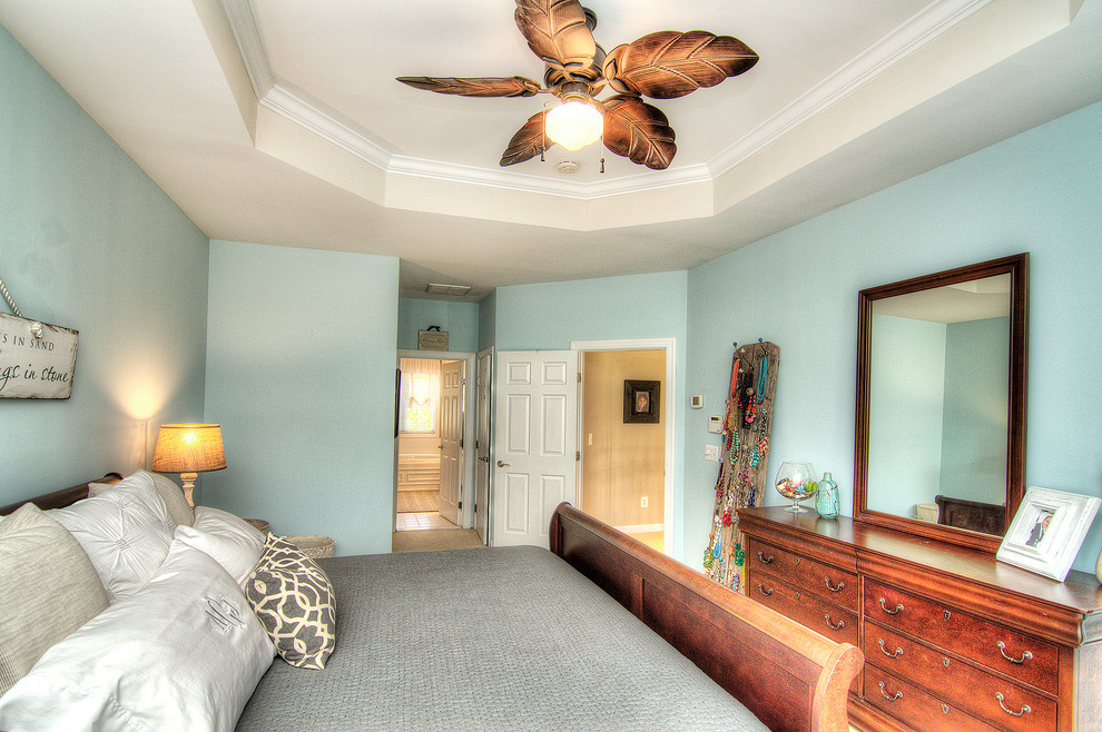 シャーロットにある中くらいなビーチスタイルのおしゃれな主寝室 (青い壁、カーペット敷き)