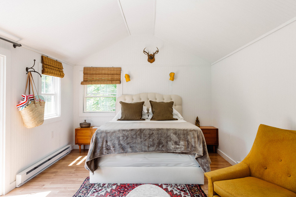 Modelo de dormitorio principal de estilo de casa de campo pequeño con suelo de madera clara y suelo blanco