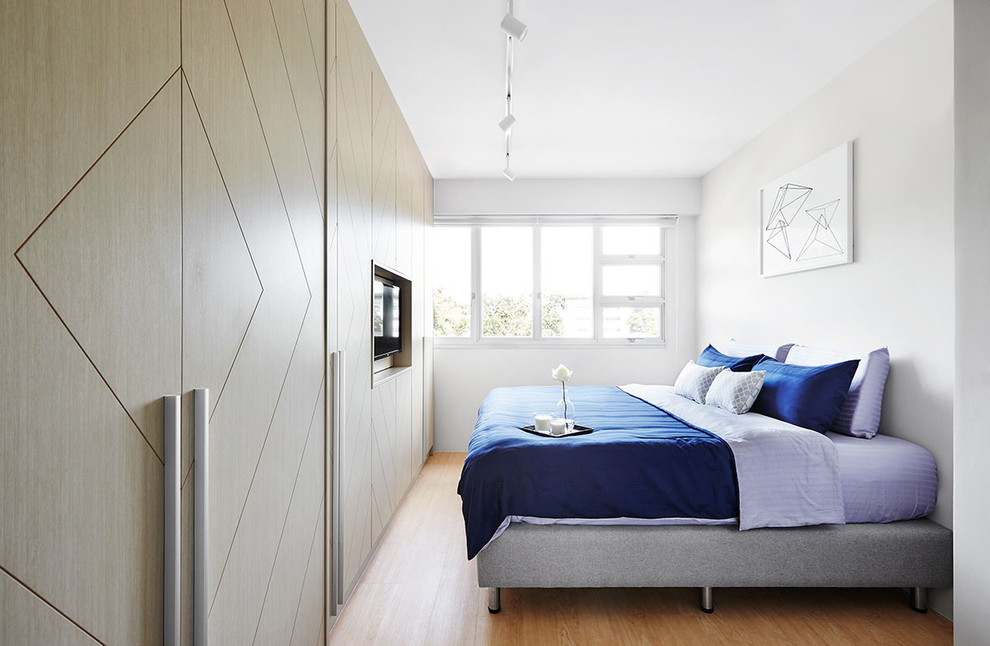 Modelo de habitación de invitados contemporánea con paredes blancas, suelo de madera en tonos medios y suelo marrón
